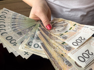woman holds and counts banknotes Polish money zl pln zltoy  for payment