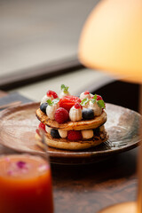 Homemade fluffy pancake with fruits and cream on the top.