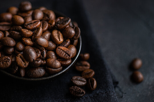 Close-up of roasted coffee beans in a dark bowl