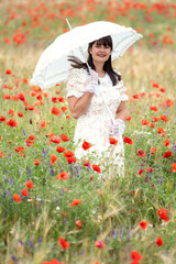 Young lady in 1920s look with hat in poppy field