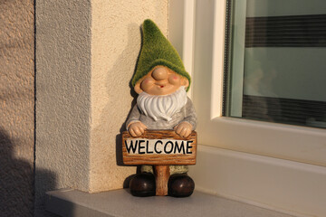 Garden gnome stands on the windowsill