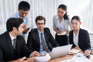 Diverse of business people from various ethnic group working in modern office environment. Productive and multi ethnic office workers engage in discussion for strategic business marketing. Meticulous