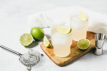 Refreshing detox citrus drink. Vitamin water with lime slices and ice cube on wooden board....