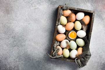 Raw organic chicken eggs on hay in a wooden box. Close up.
