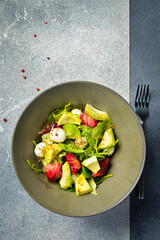 Salad with salmon, avocado, spinach and mozzarella cheese. Close up.