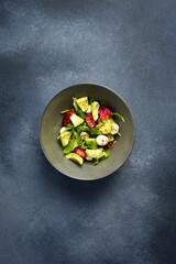 Colorful salad with fish, mozzarella cheese and spinach. Top view.