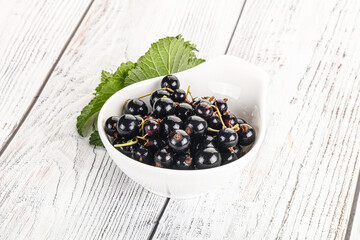 Juicy black currant berries in the bowl