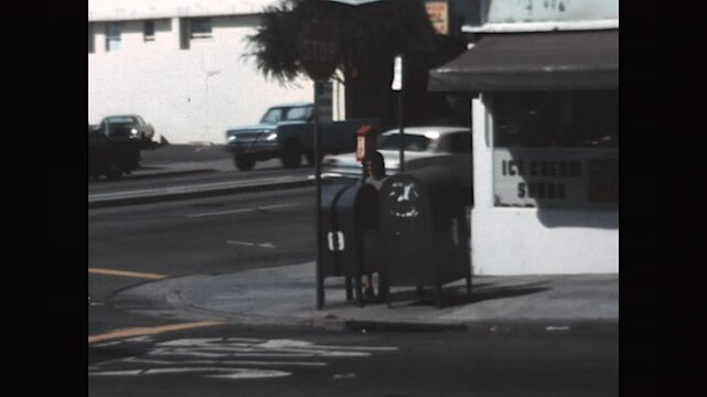 Mailing a Letter 1975 - A woman crosses the street to put a letter into a mail collection box in 1975. 