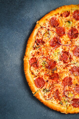 Italian pizza with pepperoni salami. Top view. Free space for text. On a gray stone background.
