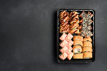 Sushi set. Sushi rolls with fish, caviar and avocado in a plastic disposable dish. Food delivery.