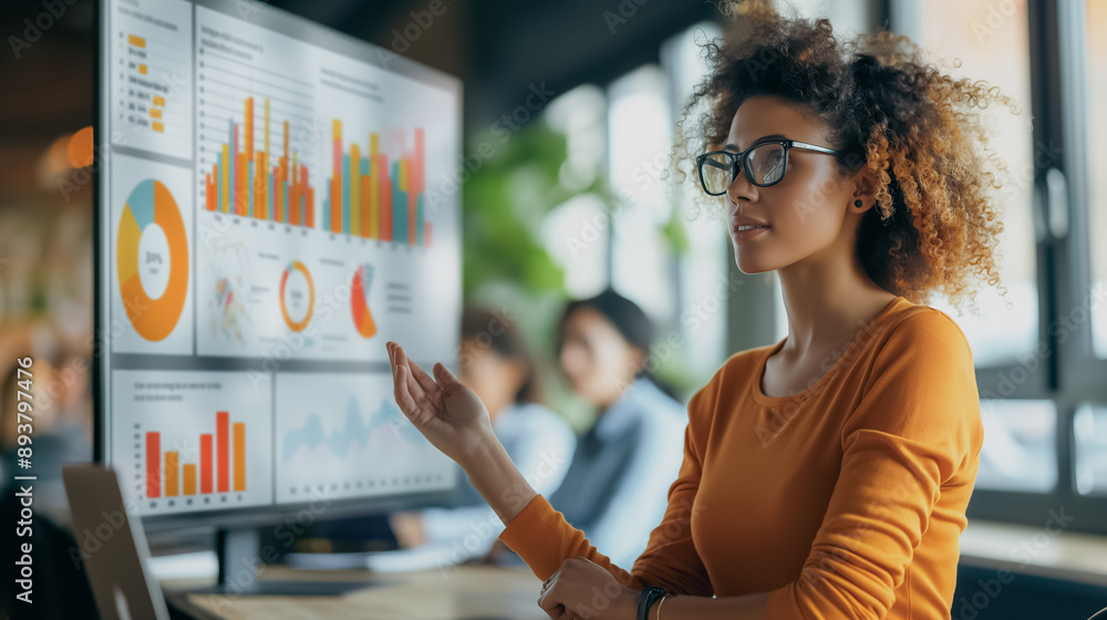 Poster data-driven insights: a young professional woman analyzes colorful charts on a large monitor, showca