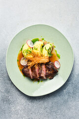 Veal steak with enoki mushrooms and potatoes. In a plate. Restaurant dish. Close up.