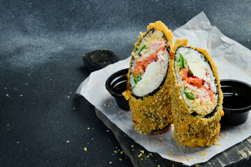 Sushi roll with salmon, avocado and cheese. Cooked in tempura. Close up.