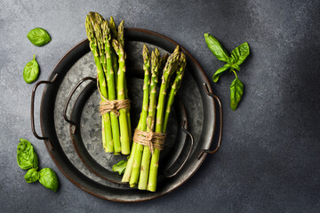 Raw fresh green asparagus on a plate. Cooking asparagus dishes. Top view.