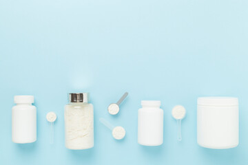 Jars with protein powder on color background, top view. Sports nutrition concept