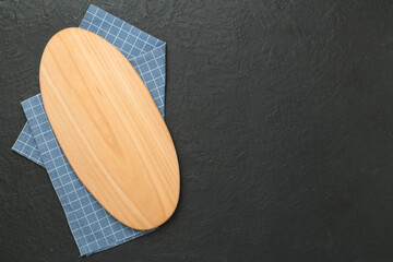 Cutting board with napkin on concrete background, top view