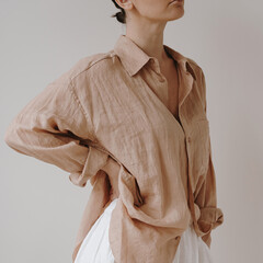 Effortless elegance with a light brown, loose linen button-up shirt paired with a high-waisted...