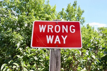 A close view of the red and white wrong way sign.