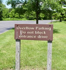 A close view of the old wood overflow parking sign.