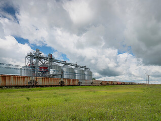 Large grain bins and parked train at the village of Lajord, Saskatchewan, Canada