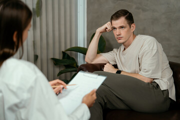 Obraz premium Stressed and depressed patient seeking help from psychiatrist with mental illness and depression in office during mental therapy session. Mental health treatment and medical care concept. Unveiling