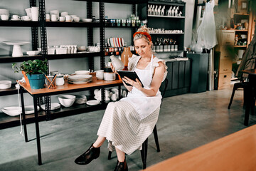 Small business, pottery or woman with tablet for check, item code or inventory in boutique. Female entrepreneur, startup or tech for logistics in ceramic workshop, online order or product information
