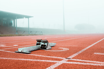 Starting blocks, track and outdoor at stadium for race, sprint or international competition in fog....