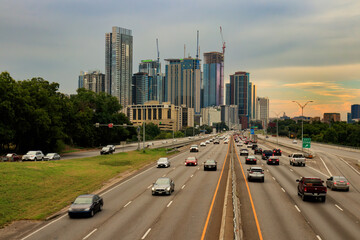 This dynamic view of the Austin, Texas skyline from Interstate 35 shows a bustling highway, lush...