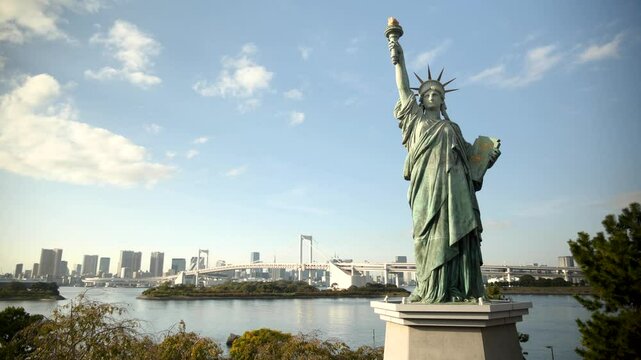 Odaiba Statue of Liberty and Tokyo skyscrapers with Rainbow bridge in the background, Japan. High quality 4k footage