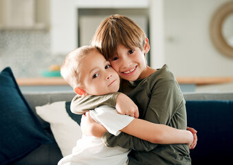 Happy boy, portrait and siblings with hug on sofa for love, support or embrace for brother at home....