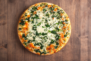 Vegetarian pizza with spinach, arugula, pesto, cheese and parmesan. Italian cuisine. 