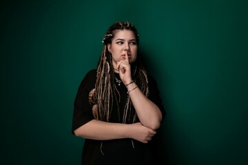 Woman With Dreadlocks Standing in Front of Green Wall