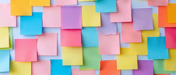 A colorful array of sticky notes covers a wall in a vibrant pattern, creating a playful and creative visual.