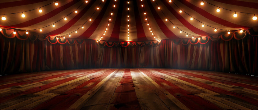 The interior of an empty striped circus tent featuring hanging lights and a wooden plank floor, creating a nostalgic ambiance.