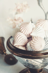 Small white meringues in a white dish on the table.