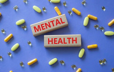 Mental Health symbol. Concept word Mental Health on wooden blocks. Beautiful purple background with pills. Medicine and Mental Health concept. Copy space