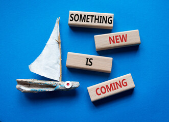 Smth New is coming symbol. Wooden blocks with words Something New is coming. Beautiful blue background with boat. Business and Something New is coming concept. Copy space.