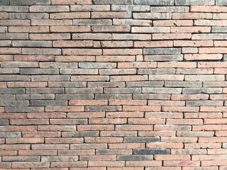 Obraz premium Brick wall background is a wall made of clay bricks, giving the structure strength and cement line between bricks that looks beautiful. It is popular to build a wall of ancient monuments.copy space,