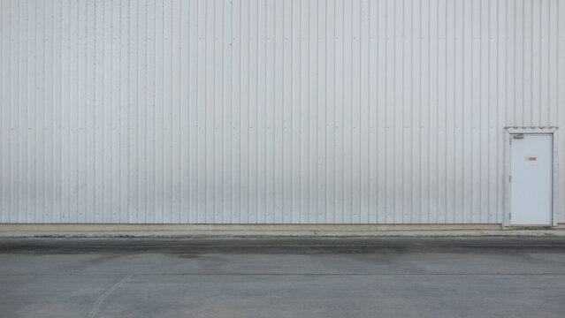 outer wall of a large warehouse with access doors for caregivers. The metal wall background of the spacious storage warehouse and caretaker entrance on the wall also provides space for messages.
