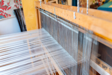 Weaving, traditional crafts,Close-up of a loom weaving, Woven silk,using cotton and silk string stretch and woven by using mechanic wooden machine to weave,