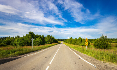 A road with a yellow sign on the side