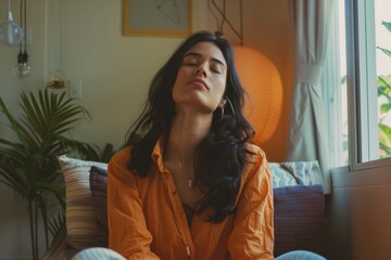 Obraz premium Candid moment of woman contemplating, sitting on couch with eyes closed.