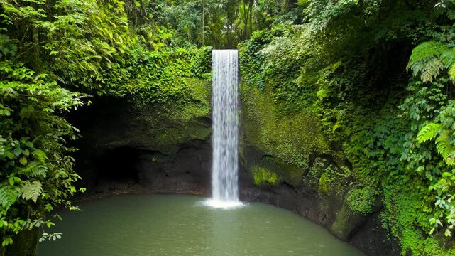 Aerial view of Tibumana waterfall, a beautiful hidden waterfall in rainforest, Bali, Indonesia.  Tibumana Waterfall referred to by locals as Air Terjun Tibumana is one of the most beautiful place.