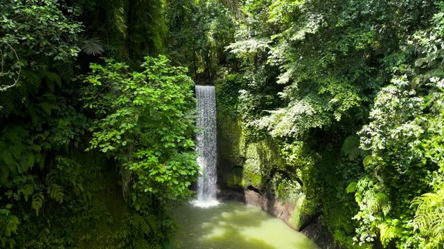Aerial view of Tibumana waterfall, a beautiful hidden waterfall in rainforest, Bali, Indonesia.  Tibumana Waterfall referred to by locals as Air Terjun Tibumana is one of the most beautiful place.