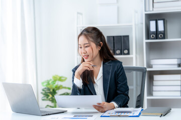 Confident businesswoman in a modern office setting, holding a document and smiling, showcasing professional work environment.