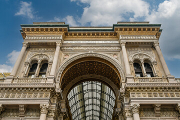 Low-angle view of the triumphal arch entrance to Galleria Vittorio Emanuele II (1877), Italy's oldest active shopping arcade, located in Piazza del Duomo, Milan, Lombardy, Italy