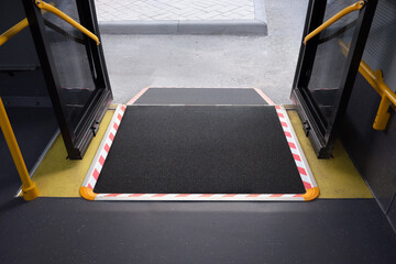 Inclined platform mechanical lift for disabled people in a city bus.
