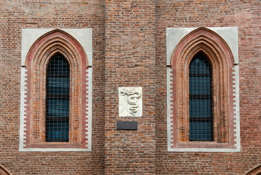 The Biscione ("big grass snake"), heraldic symbol of the House of Visconti, between a pair of windows on the facade of the church of Santa Maria Incoronata, Milan, Lombardy, Italy
