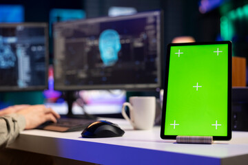Focus on isolated screen tablet next to man in blurry background talking with AI gaining...