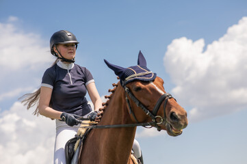 Portrait of a girl jockey riding a horse. 
